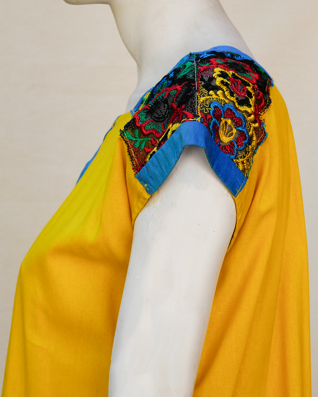 Blusa de lino amarillo con bordes de seda azul con bordado.