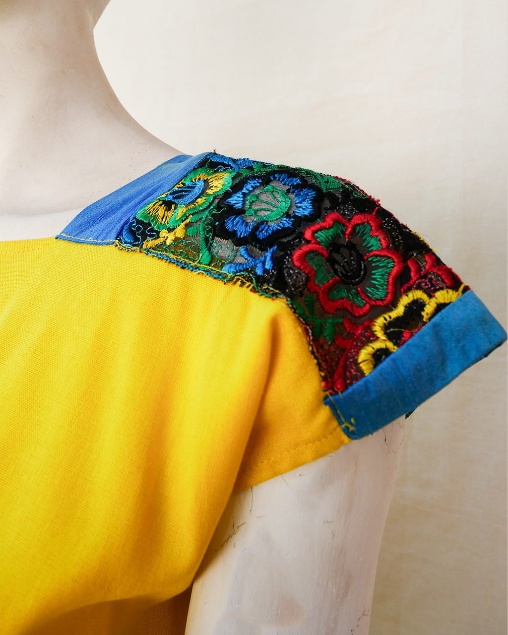 Blusa de lino amarillo con bordes de seda azul con bordado.