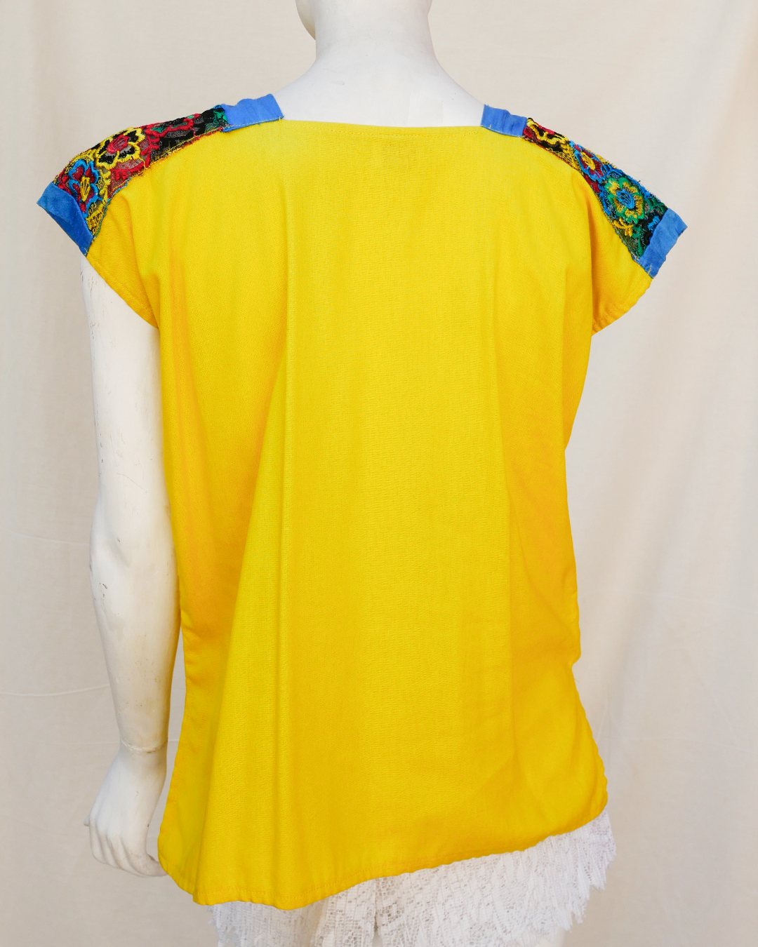 Blusa de lino amarillo con bordes de seda azul con bordado.