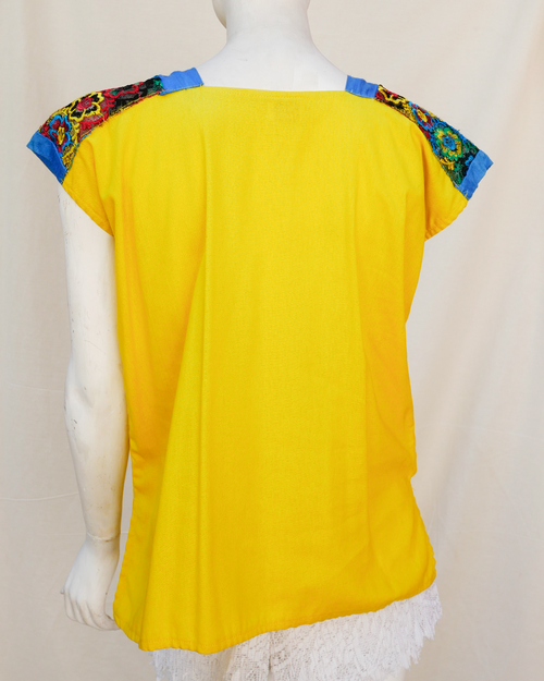 Blusa de lino amarillo con bordes de seda azul con bordado.