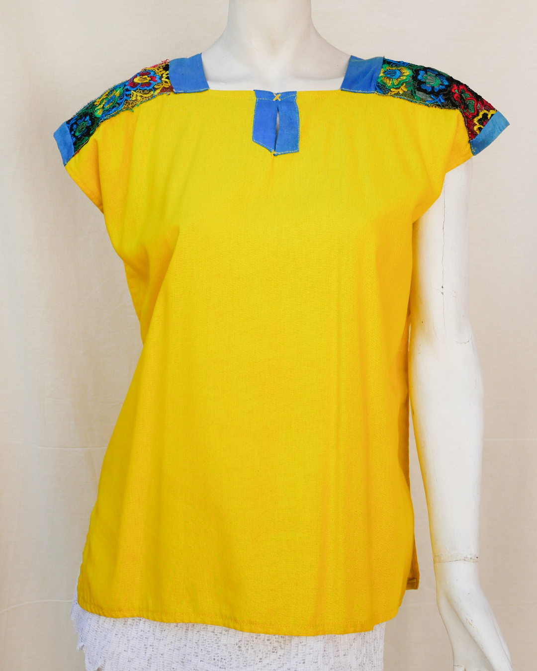 Blusa de lino amarillo con bordes de seda azul con bordado.