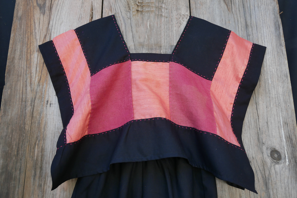 Huipil rosa con pantalón de lino negro.