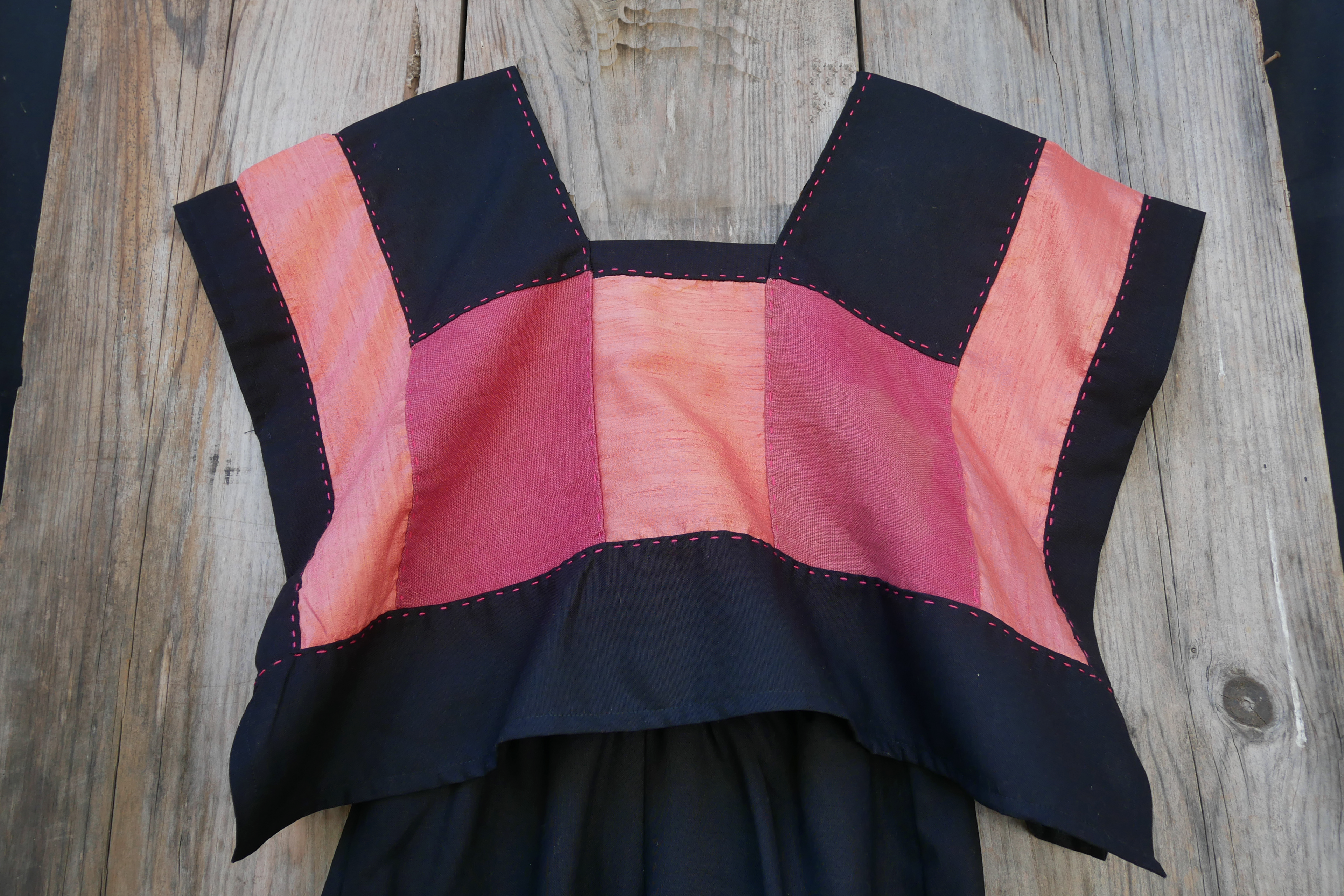 Huipil rosa con pantalón de lino negro.