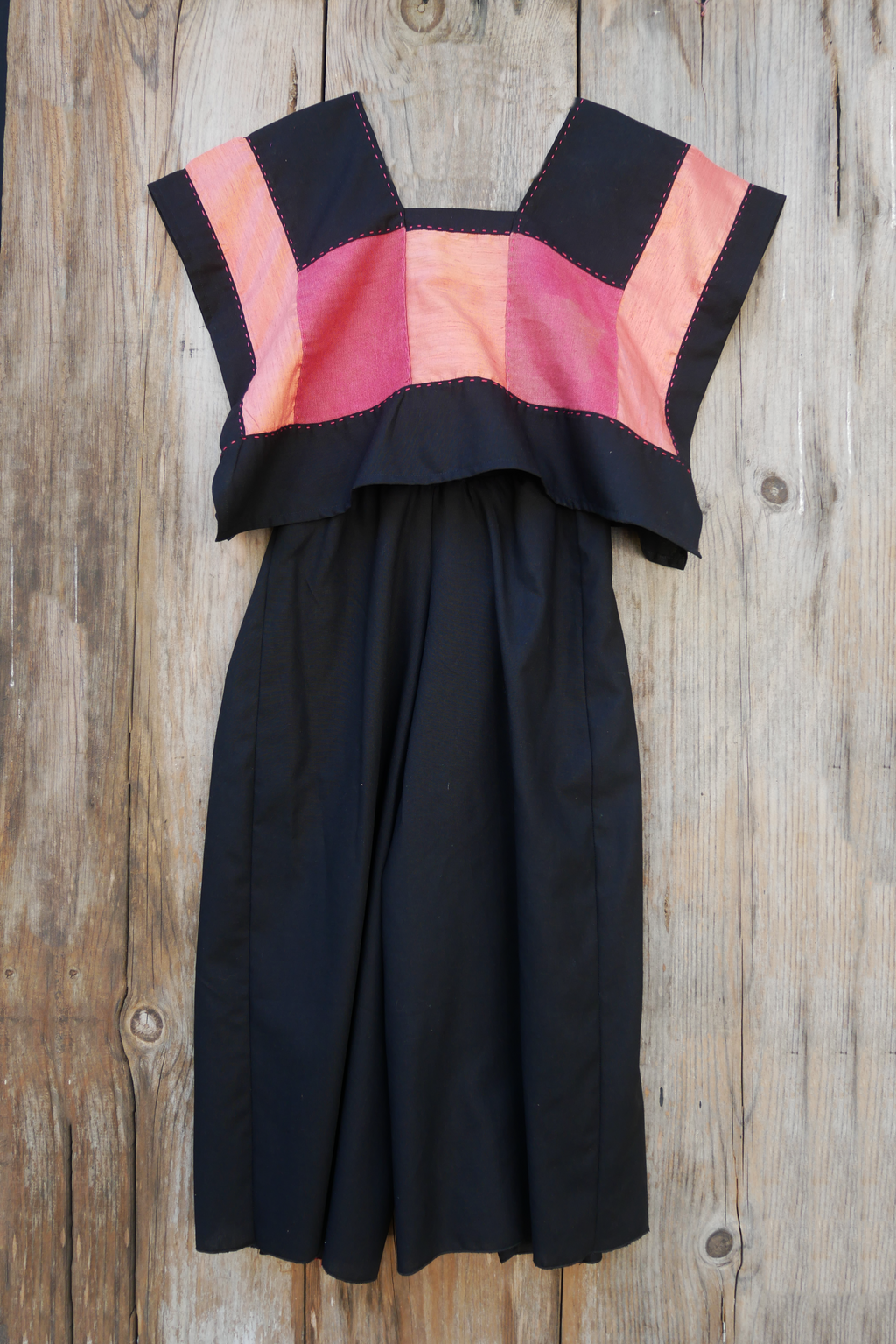 Huipil rosa con pantalón de lino negro.